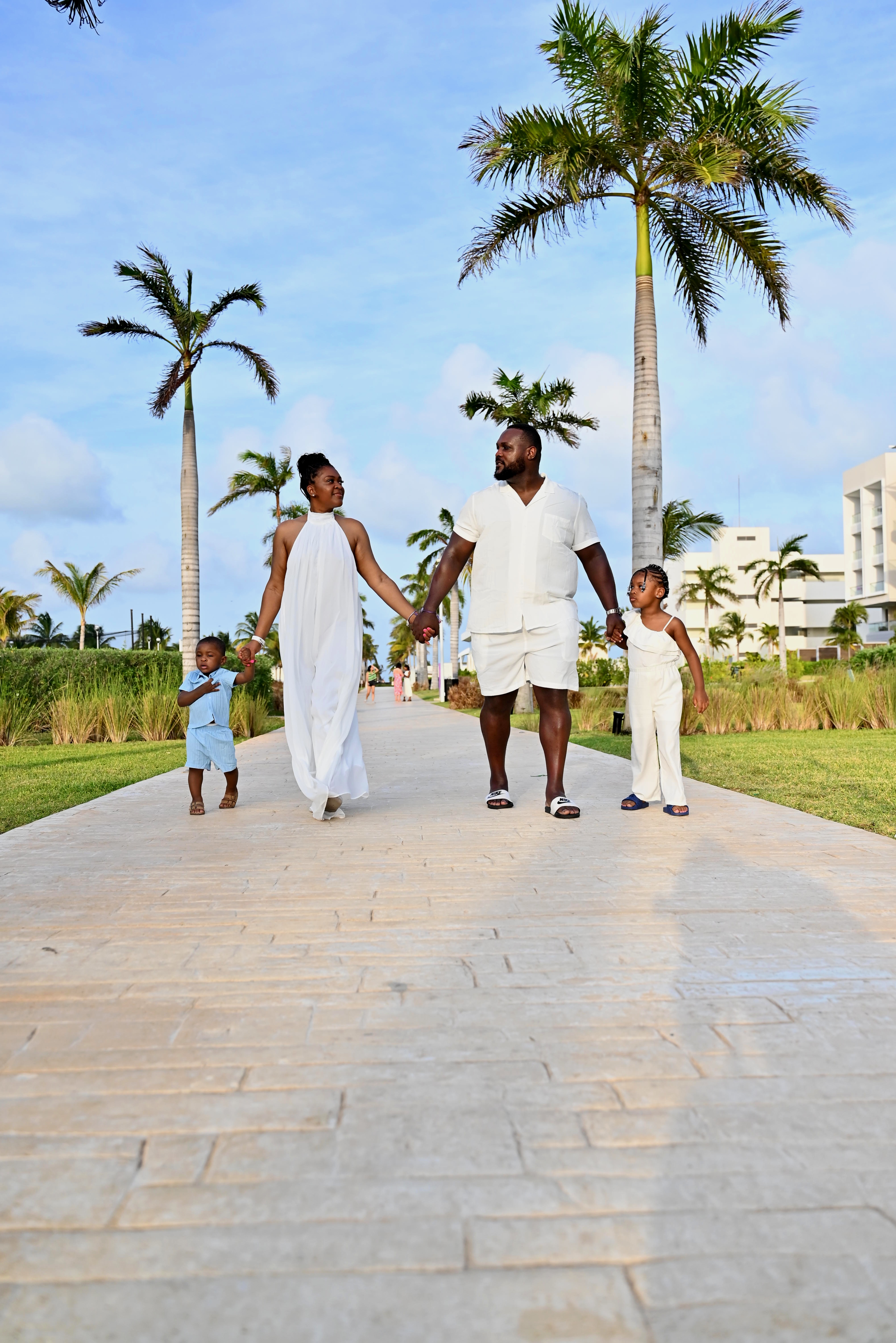 Family walking together under palm trees on a tropical vacation